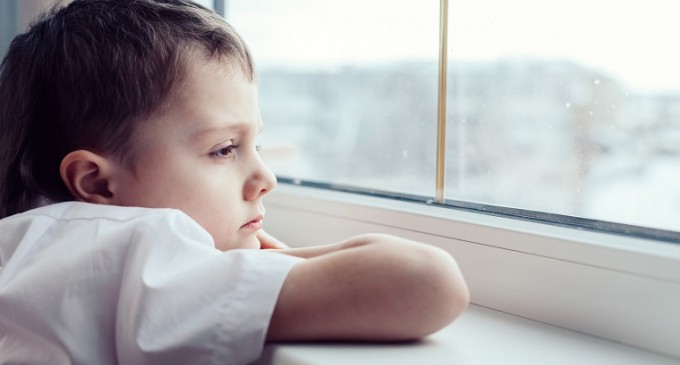 dziecko patrzące w dal przez okno